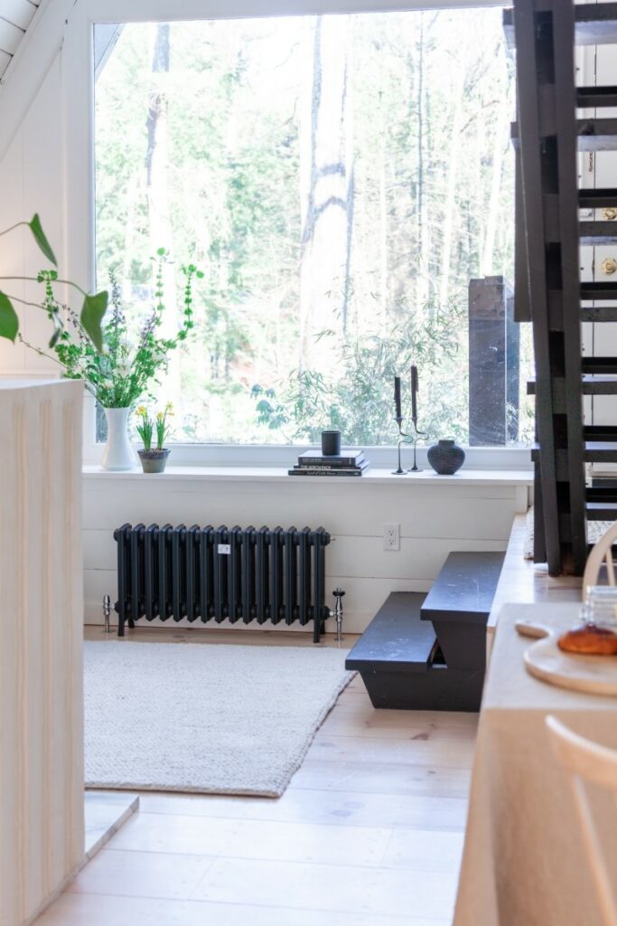 A lifestyle photo of a Grace 4 Column cast iron radiator 20" in Farrow & Ball's 'Black Blue' in The Triangle House.